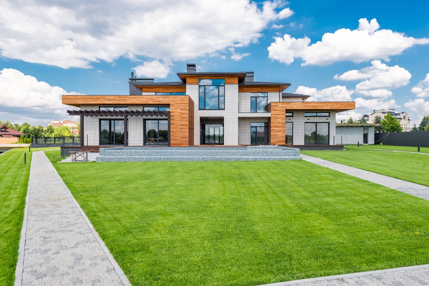 A contemporary home with large windows and a landscaped lawn